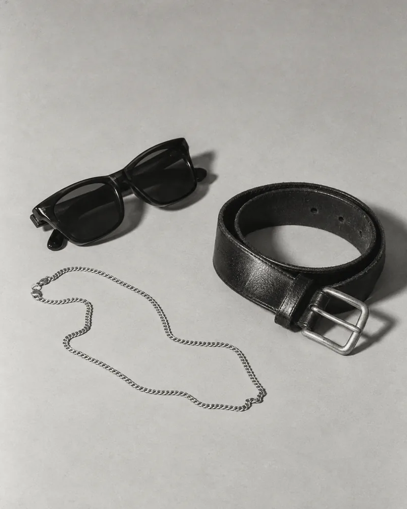 Illustrative vintage sunglasses, leather belt and silver chain